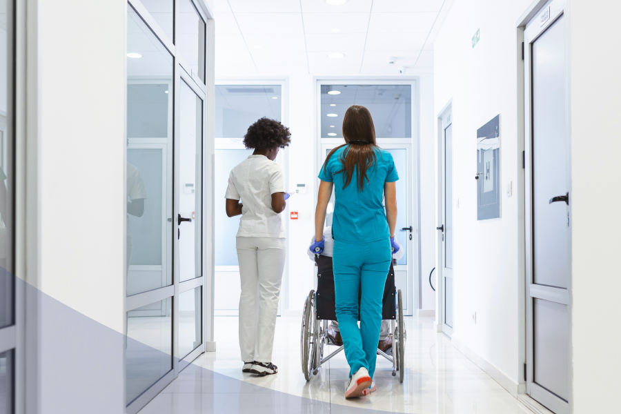 Medical staff members pushing a patient in a wheelchair