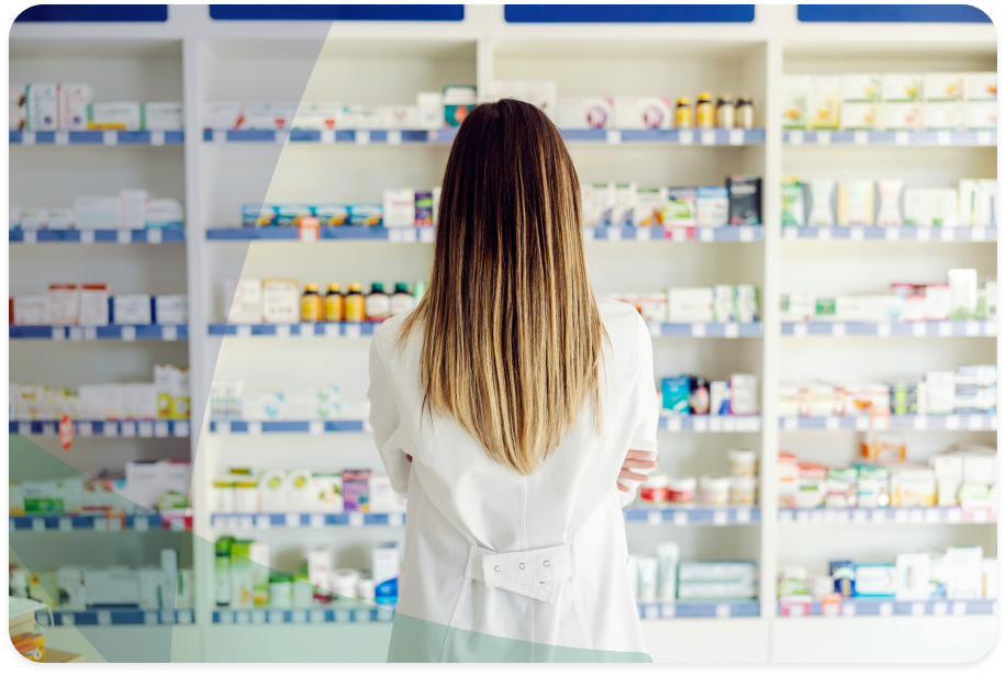 Pharmacist facing away from the camera and looking at shelves full of medication